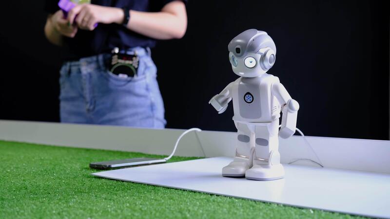 child programming humanoid robot - Engineer programming humanoid robot showing movements in slow ...