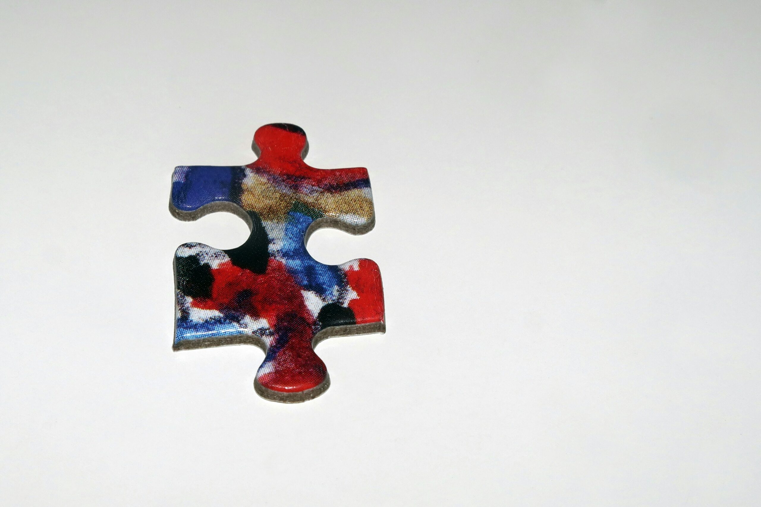 Robot arm holding jigsaw puzzle piece - Colorful jigsaw puzzle piece on white background
