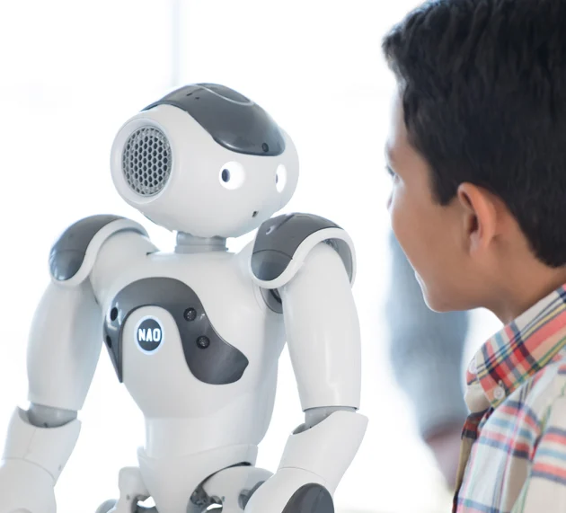 child playing with humanoid robot - Kids Learn Better When Playing with Robots